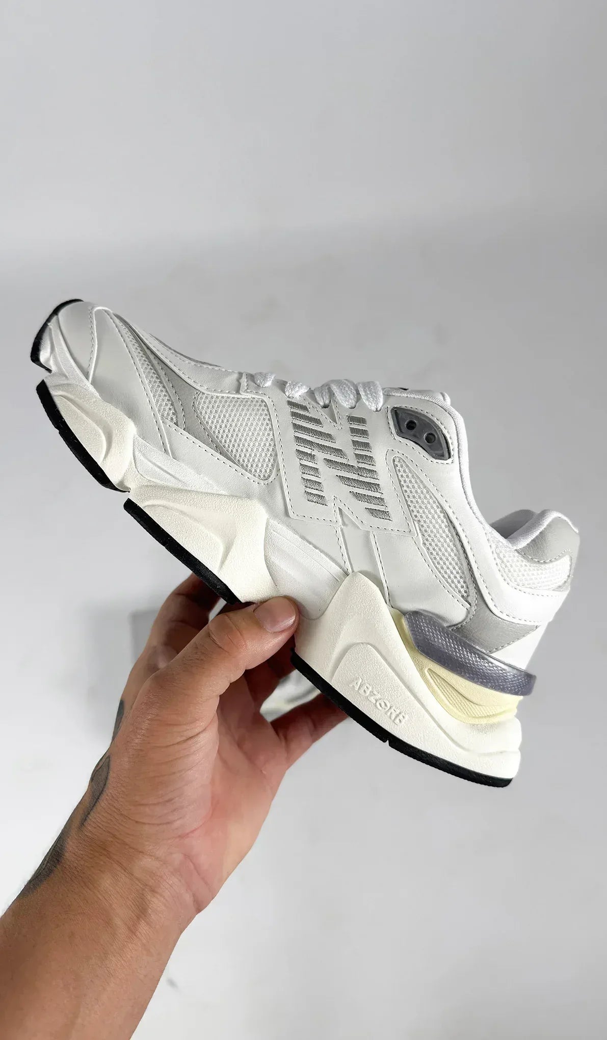 New Balance 9060 sneakers, featuring a predominantly white colorway with textured mesh and leather panels.