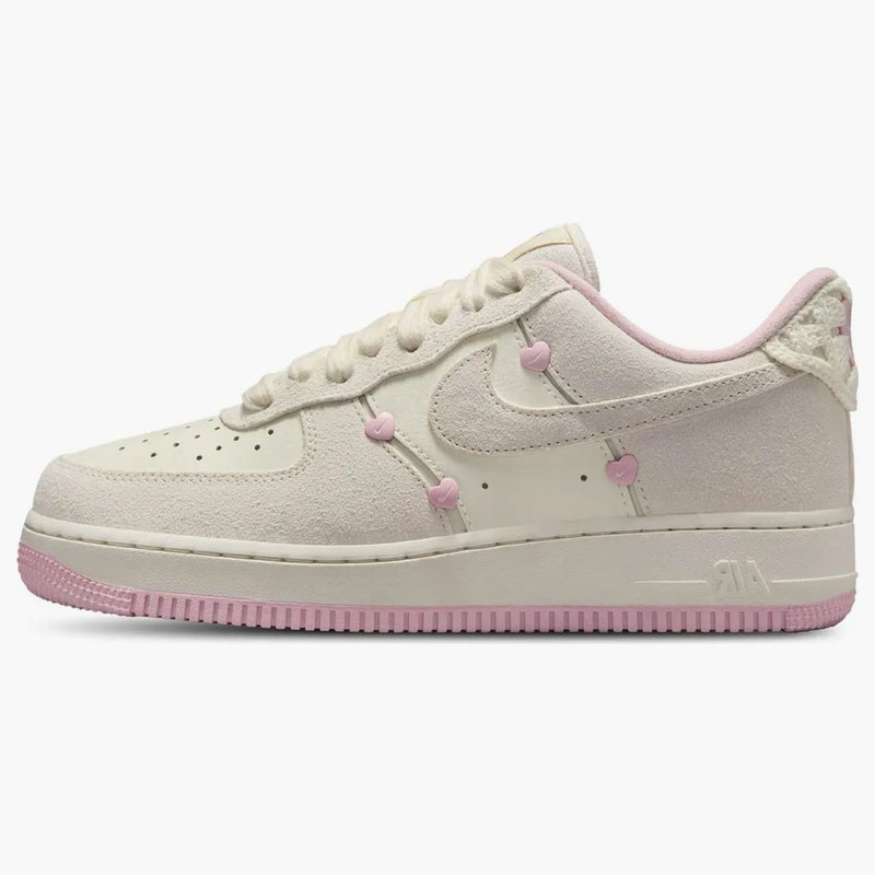Nike Air Force 1 Low "Valentine's Day" sneakers featuring light beige suede overlays and small pink heart details along the Swoosh.