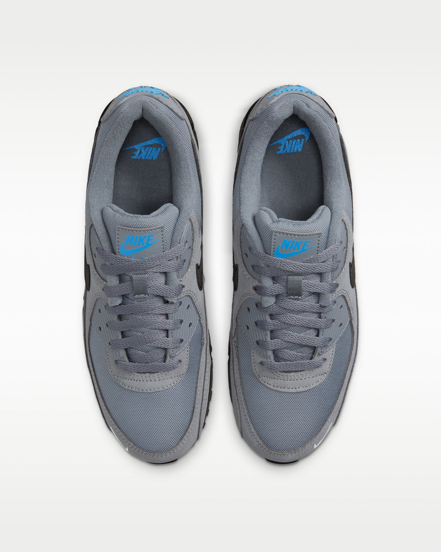 Nike Air Max 90 sneakers featuring a grey suede and mesh upper with a black midsole and swoosh.