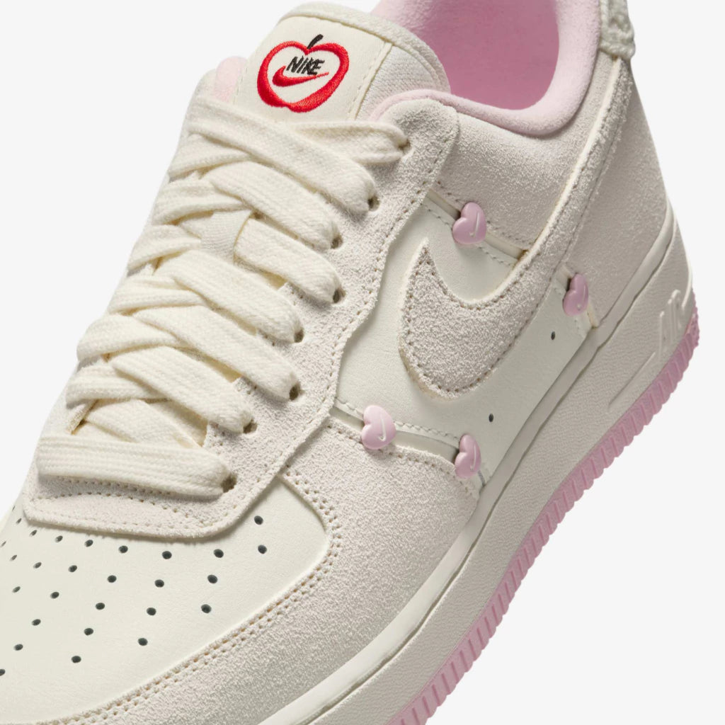 Nike Air Force 1 Low "Valentine's Day" sneakers featuring light beige suede overlays and small pink heart details along the Swoosh.