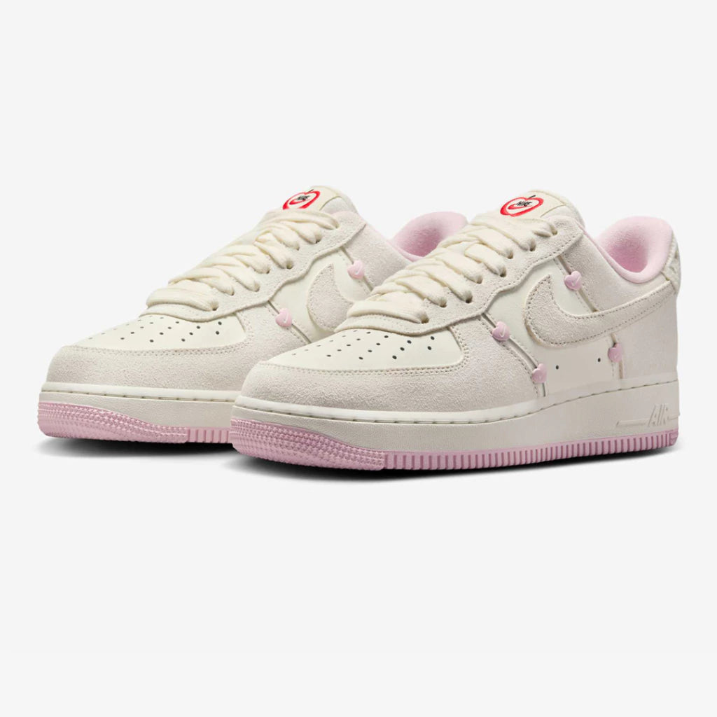 Nike Air Force 1 Low "Valentine's Day" sneakers featuring light beige suede overlays and small pink heart details along the Swoosh.