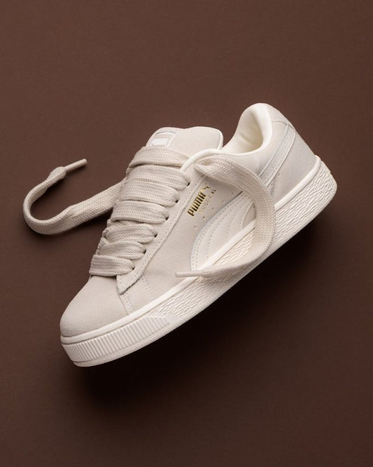 PUMA Suede XL sneakers in an "Alpine Snow" or "Ecru" colorway, featuring chunky, corded laces and a thick platform sole.