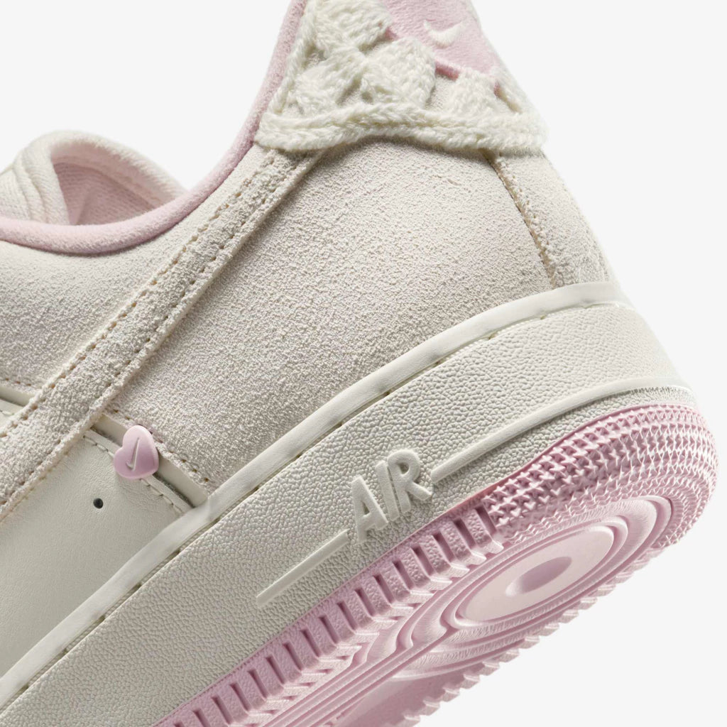 Nike Air Force 1 Low "Valentine's Day" sneakers featuring light beige suede overlays and small pink heart details along the Swoosh.