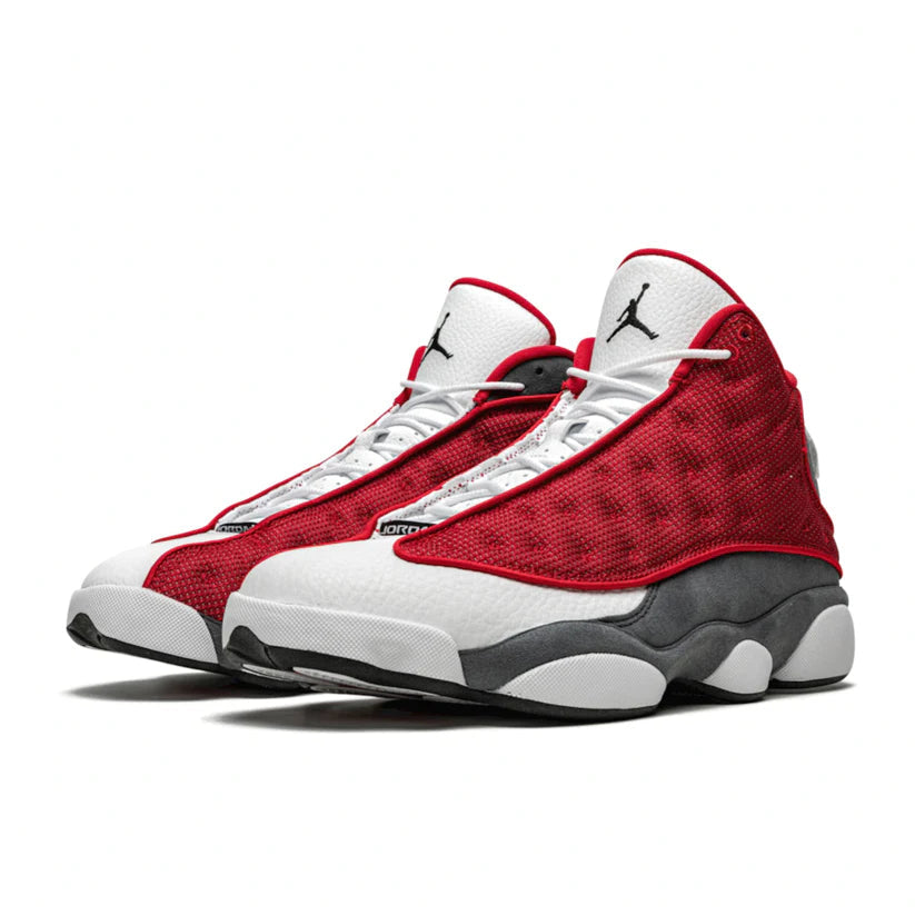 Nike Air Jordan 13 Retro sneakers in the "Gym Red Flint" colorway, featuring red reflective mesh panels.