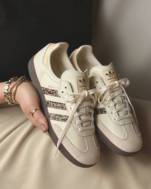Adidas Samba OG shoes, featuring a cream-colored leather upper and a distinctive leopard print on the signature three stripes.