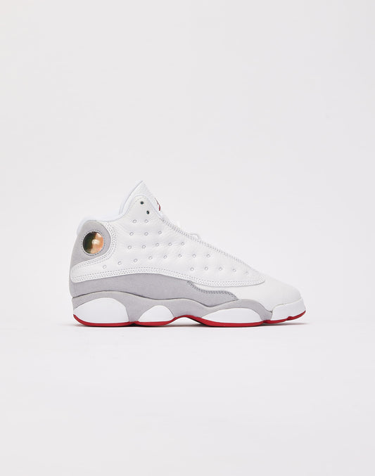 These are the Nike Air Jordan 13 Retro "Wolf Grey" sneakers, featuring a white tumbled leather upper with a signature green holographic eye on the heel.