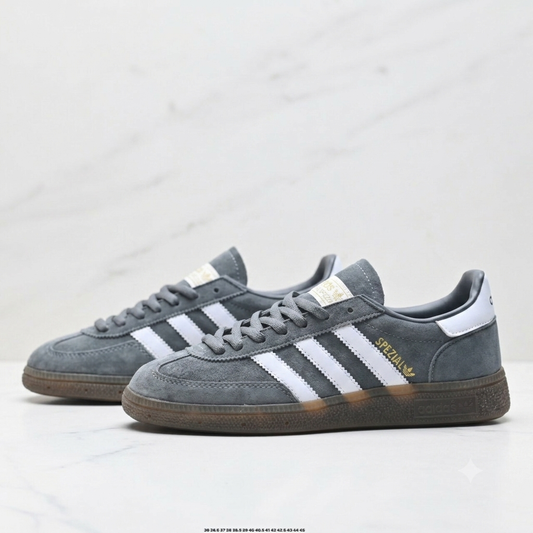 Adidas Handball Spezial sneakers, featuring a grey suede upper, white stripes, and a classic brown gum sole.