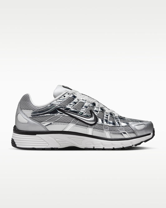 Nike P-6000 shoes feature a metallic silver and white colorway with breathable mesh paneling.