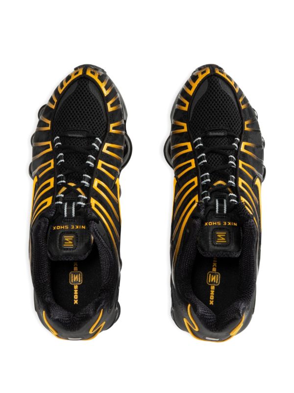 Nike Men's Shox TL sneakers in black and gold.