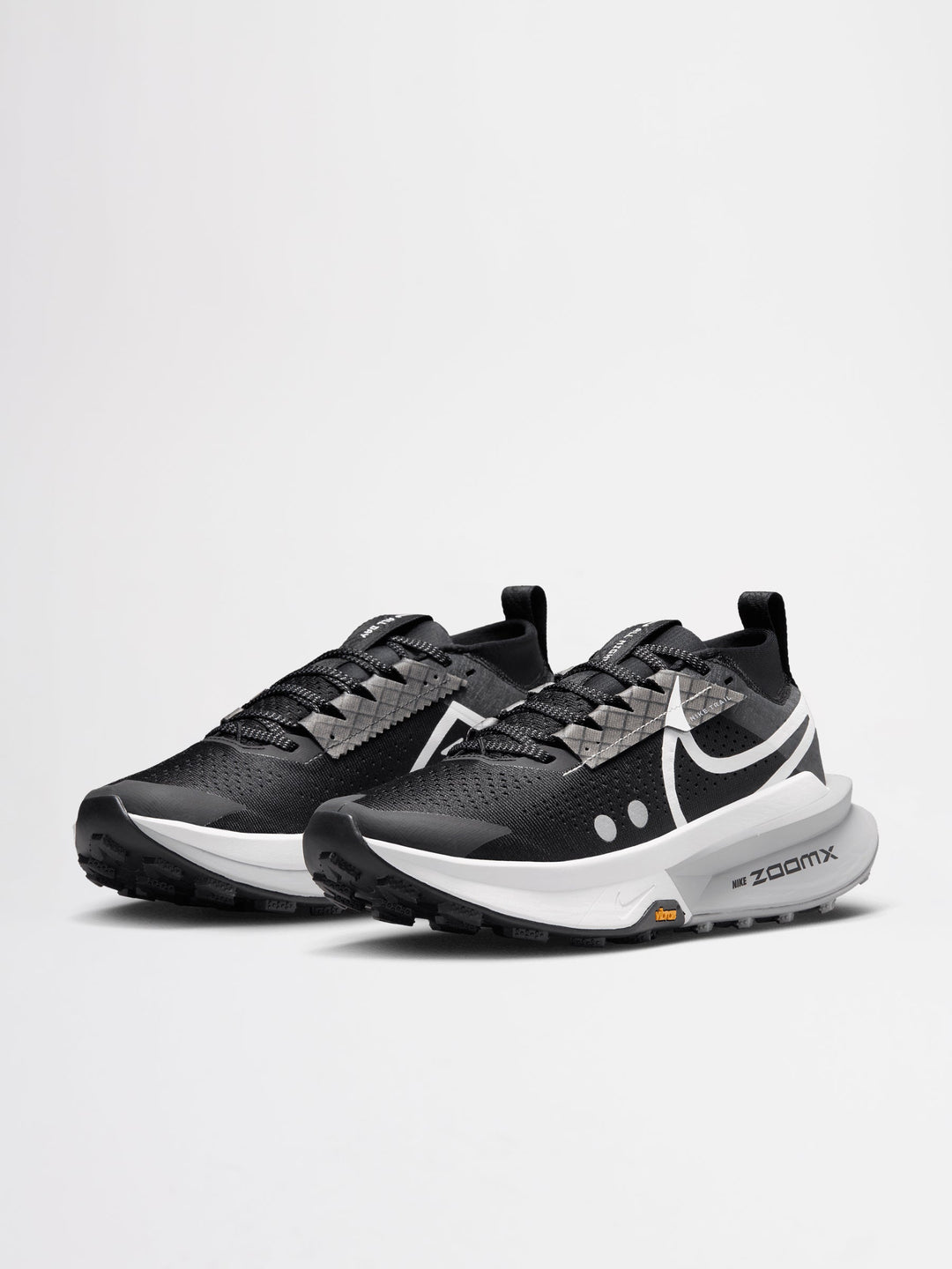Nike Zegama Trail 2 running shoes in a black, white, and wolf grey colorway, featuring a durable Vibram outsole for traction.