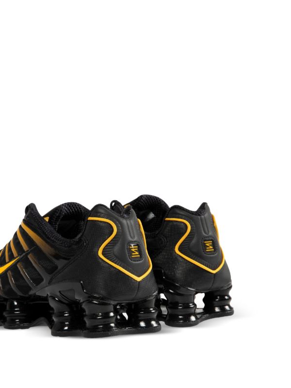Nike Men's Shox TL sneakers in black and gold.