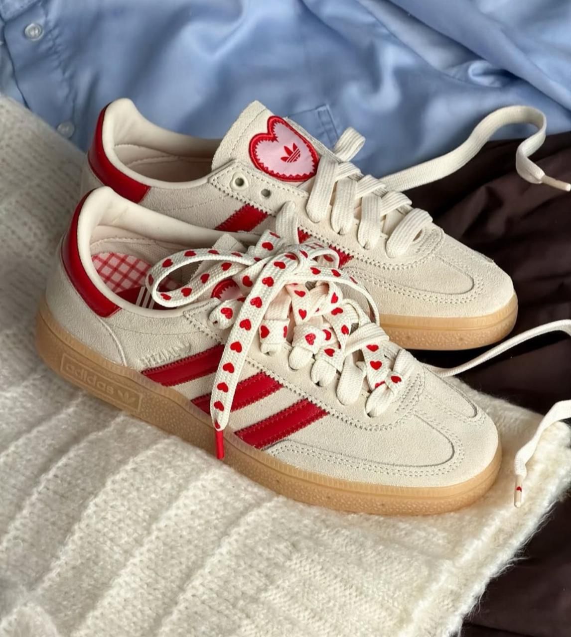 Adidas Handball Spezial sneakers in an off-white and red colorway,