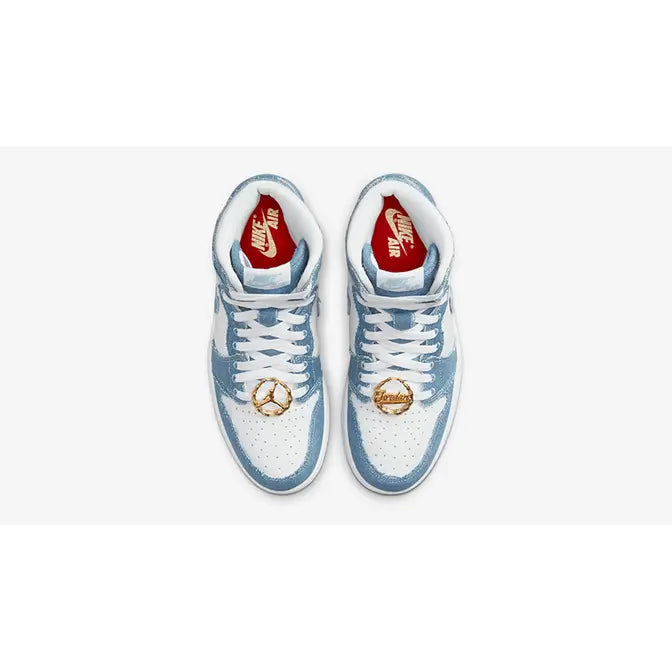 Women's Air Jordan 1 Retro High OG "Denim" sneakers, featuring frayed blue denim overlays on a white leather base and metallic gold lace dubraes.
