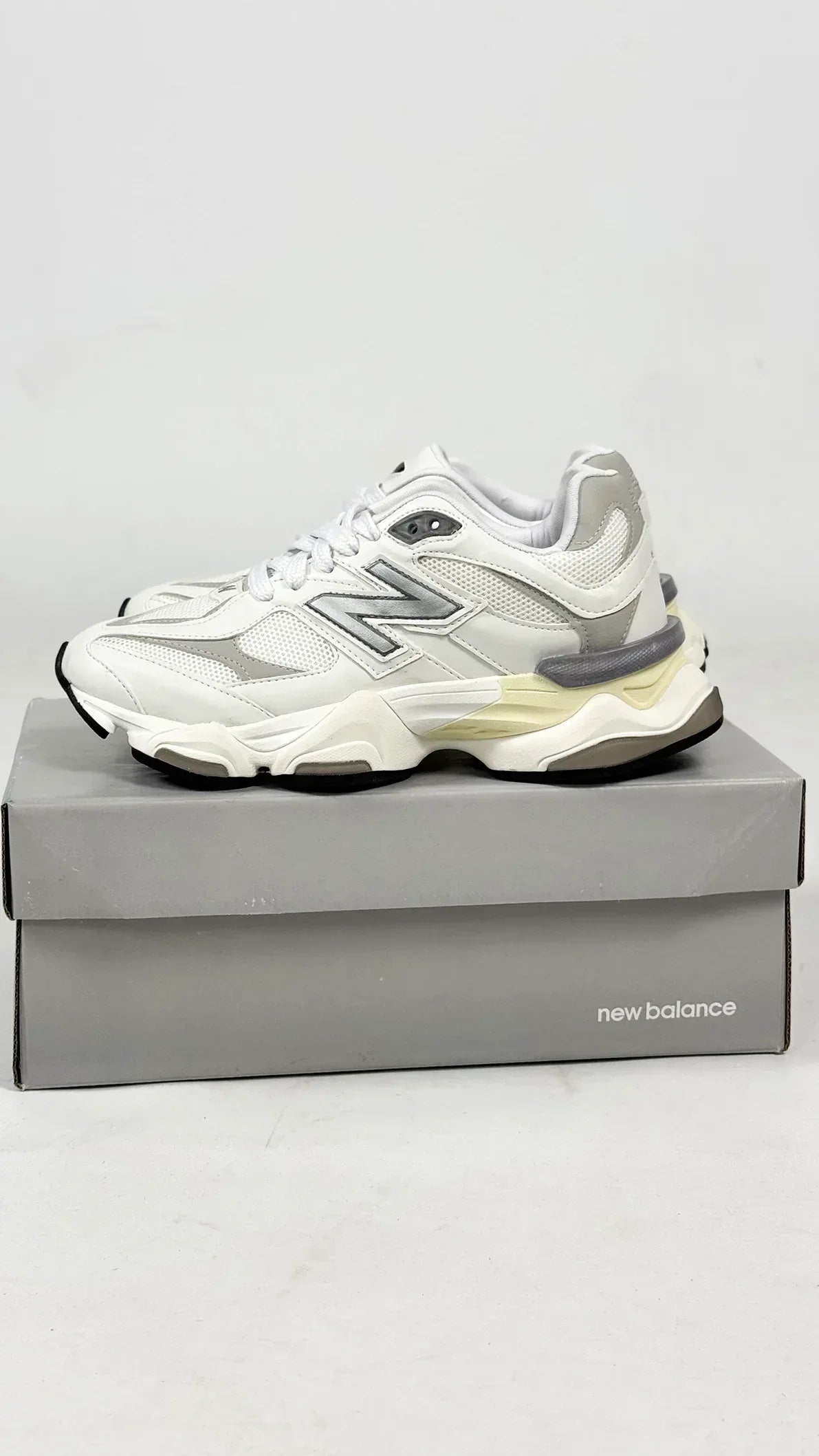 New Balance 9060 sneakers, featuring a predominantly white colorway with textured mesh and leather panels.